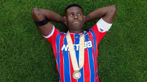 Marc Guehi lies on the Wembley pitch staring up at the sky with his winners medal around his neck