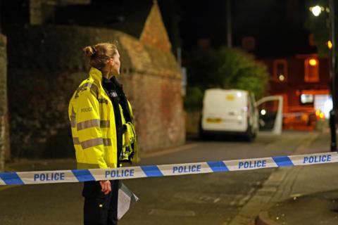 Police officer stands by at a police cordon at a crime scene