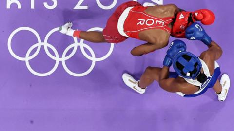 France's Davina Michel of France in blue goes up against Cindy Ngamba of the Refugee Olympic team in red at the Paris Olympics