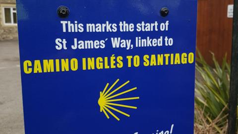 A blue sign that reads 'This marks the start of St James' Way, linked to Camino Ingles to Santiago'