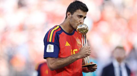 Rodri kisses the World Cup trophy