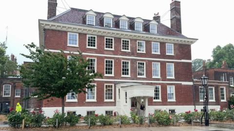 Exterior of a large red-brick, four storey house