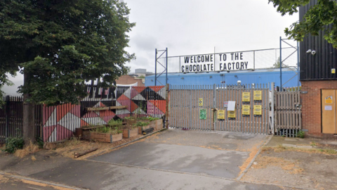 The entrance to the site with Welcome To The Chocolate Factory written over the gates