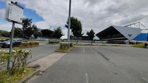 Kassam Stadium car park with new sign in foreground