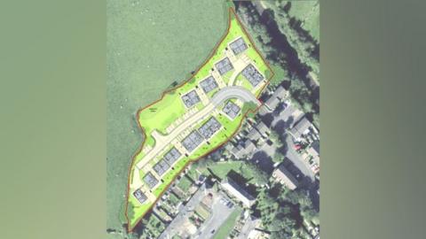 An aerial view of a proposed development showing a number of houses separated by a road 