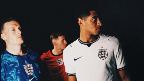 Jordan Pickford (left) wears the new blue goalkeeper shirt, Elliot Anderson (centre) has the red away jersey on and Jude Bellingham is wearing the white home shirt.
