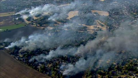 Smoke rises into the sky from homes that are on fire
