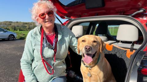 Anna Addison-Milne sat in the boot of her car with her dog