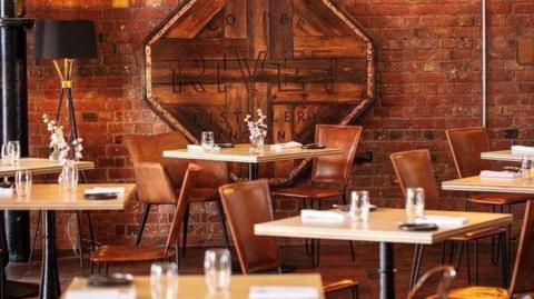 Empty chairs and tables at the Pumproom Restaurant in Chatham. Glasses and napkins are all on the table.