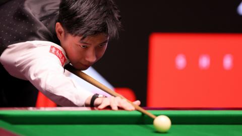 Zhao Xintong plays a shot
