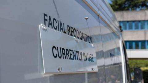 Sign on the side of a van indicating facial recognition cameras are in use