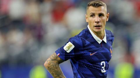 Lucas Digne looks on for France