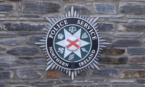 The Police Service of Northern Ireland badge on a stone wall.