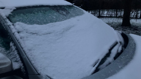A car windscreen covered in snow