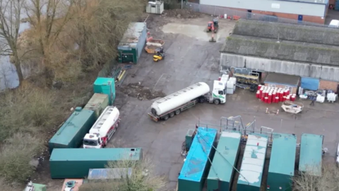 A bird's eye view of tankers and lorries in a depot.