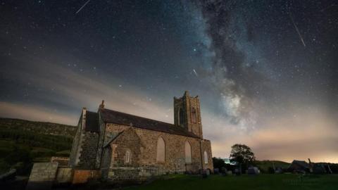 Meteors streaking though clear skies over a church in Northern Ireland