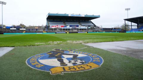 A general view inside the Memorial Stadium with the Bristol Rovers badge on the pitch and a stand in the background