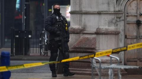 Police during a standoff in Lewisham High Street in south-east London after a man in a dressing gown was seen brandishing a knife out of the window of a building.