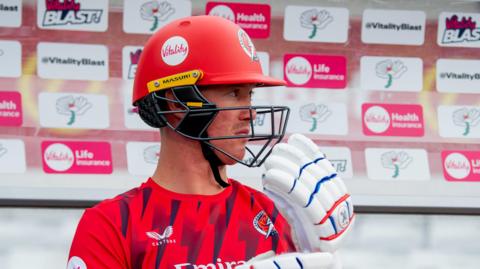 Keaton Jennings sitting in a T20 Blast dugout with his helmet and gloves on