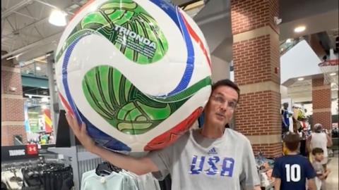 Kevin Cronin holding up a massive World Cup football