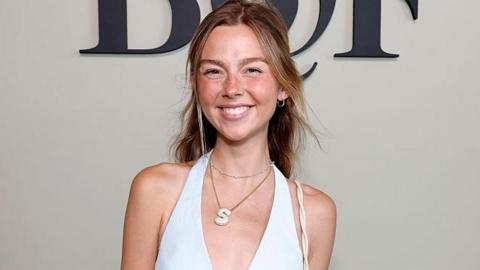 Towle, wearing a white top, smiling very big