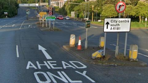 Road with a red sign indicating no right turn