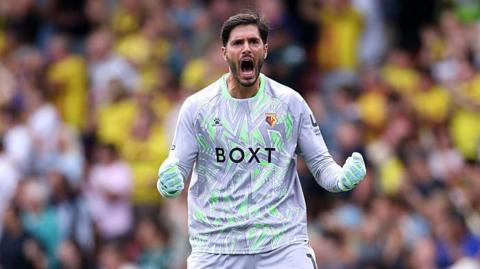 Watford keeper clenches both his fists in celebration of a goal