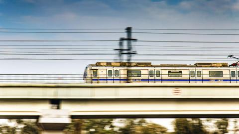 A speeding New Delhi Metro Train running on its elevated track.