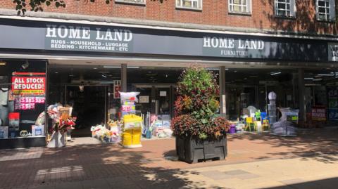 Shopfront of 91ȱland Furniture on Carverley Road - a sign in the window reads 'all stock reduced!'. 