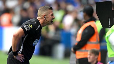 Feferee Robert Jones checks the VAR screen during a match between Fulham and Chelsea
