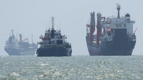 Vessels in the Strait of Hormuz are visible near the beach of Bandar Abbas, Iran, August 25, 2026