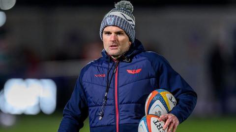 Scarlets defence coach Jared Payne carrying two rugby balls during a warm-up