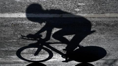 The shadow of a rider who is competing in a professional cycling race