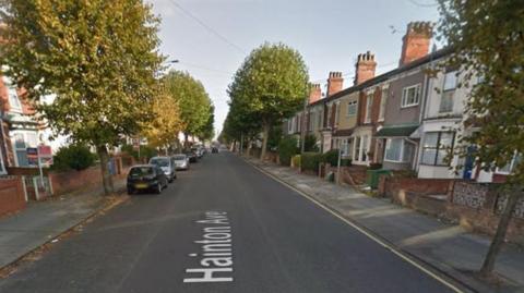 A Google image showing a straight section of Hainton Avenue, Grimsby. The street is flanked by trees both sides.