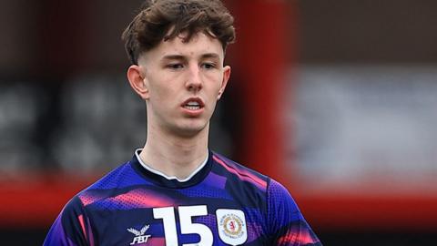 Joe White warming up for a game during his loan spell with Crewe. He is wearing an away purple and pink shirt