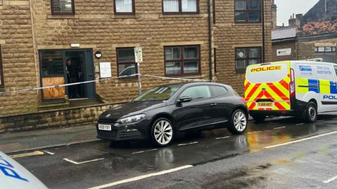 Crime scene investigation van and a police cordon outside flats in Strawberry Dale, Harrogate.