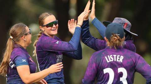 Scotland celebrate a wicket for Darcey Carter (second left)