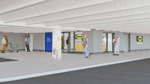 An artist's impression of the entrance to the Ikea store which is in a grey multi storey car park with the yellow and blue signage of the store seen on walls and windows. There are people walking along, two pushing a trolley.