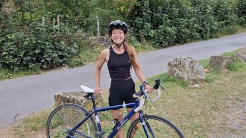 Cara Grimwade with a bike and a path behind her