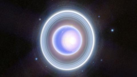 A blurry photo from a space telescope showing Uranus and some new moons