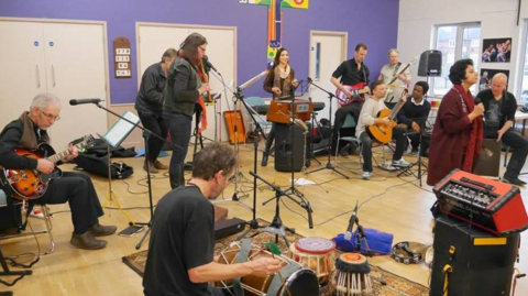 Performers from Confluence Collective Oxford singing and playing musical instruments on one of their sessions.