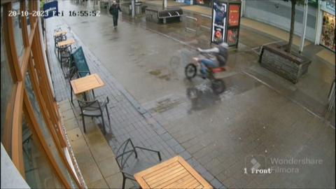 Teenager riding e-bike through a pedestrianised Port Talbot shopping street