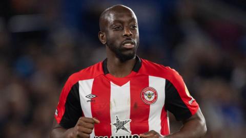 Yoane Wissa in a red and white striped Brentford match shirt