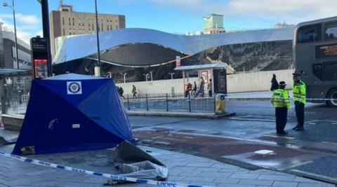 A blue police tent at the spot of a stabbing in Birmingham city centre. Grand Central can be seen in the background.