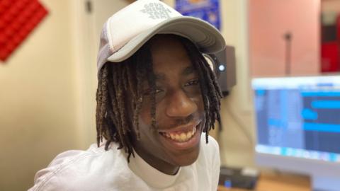18-year-old Cedric Kwarteng wearing a grey hat and white T-shirt