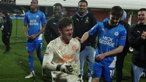 Jed Steer smiles as he picks up his man of the match award for saving two Wrexham penalties from Paul Mullin and Elliot Lee