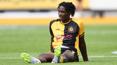 Habeeb Ogunneye of Newport County sits dejected on the field after defeat