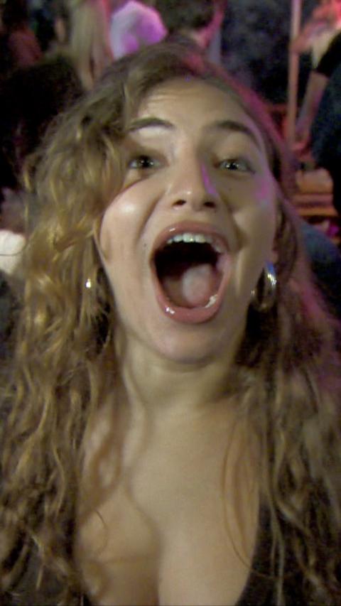 And England fan, a woman with long brown hair, screams with delight