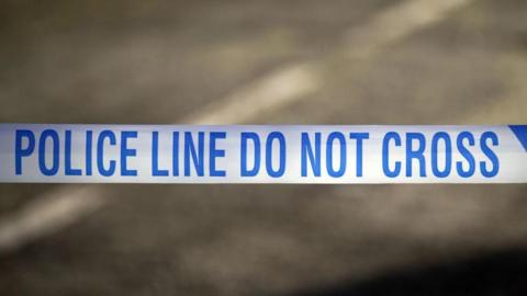 Police tape reads "Police line do not cross" 