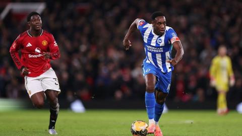 Manchester United midfielder Kobbie Mainoo chases Brighton captain Danny Welbeck at Old Trafford